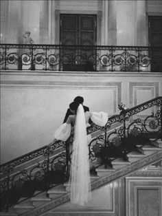 a bride and groom standing at the top of stairs