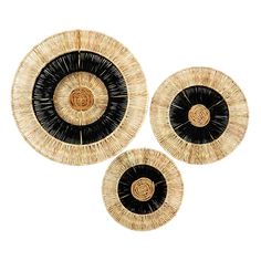 three black and white plates with circular designs on the top, one is made out of straw