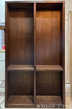 a wooden bookcase sitting in the middle of a kitchen