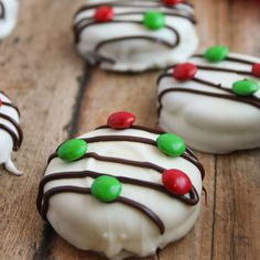 chocolate covered desserts with white frosting and candy toppings on a wooden table