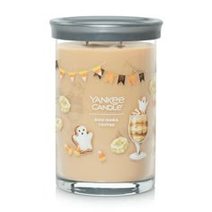 yankee candle with halloween decorations on it and a glass filled with boo - nana toffes