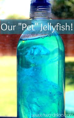 a bottle filled with blue liquid sitting on top of a table next to a window