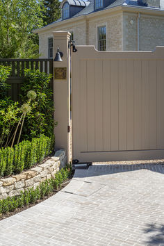 a house with a large gate and brick walkway