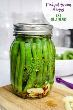 pickled green beans in a mason jar on a cutting board