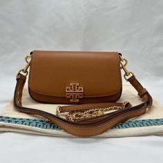 Tory Burch Nwt Tan Britten Crossbody Convertible With Dust Bag & Extra Chain 100% Authentic Comes With Coa, Not Pictured But Will Be Provided After Purchase New With Tags Not Attached,But Never Used Comes With Dust Bag And 2 Chains One Braided And One Solid Leather Strap Gold Toned Hardware Teal/Grey Inner Fabric Lining With Gold Toned Tory Burch Name Plate Magnetic Closure Pebbled Leather 1 Zipper Pocket 1 Slip Pocket Double/Detachable Strap(S) No Call Outs Please See All Photos And Ask Questio Tory Burch Britten Mini Top Handle Bag, Tory Burch Crossbody Handbags, Tory Burch Britten Crossbody Bag, Tory Burch Crossbody Bag, Tan Crossbody Bag With Gold-tone Hardware, Tory Burch Crossbody, Brown Crossbody, Convertible Bags, Crossbody Clutch