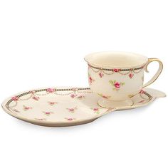 two cups and saucers with pink flowers on them, one is sitting next to the other