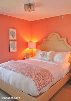 a bedroom with pink walls and white bedding, two lamps on either side of the bed