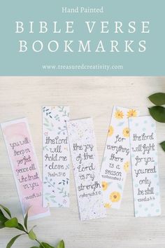 three hand painted bible verse bookmarks on a table with flowers and greenery in the background