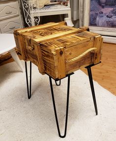 a wooden table with hairpin legs on top of carpeted floor next to dresser