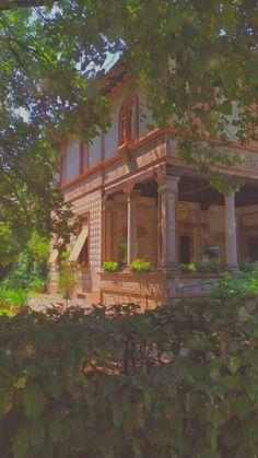 an old house is surrounded by greenery and trees