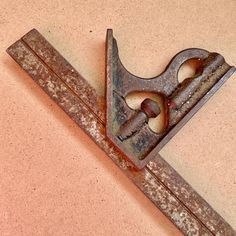 an old pair of scissors sitting on top of a piece of rusted metal with holes in the middle