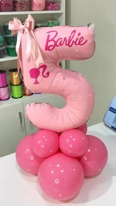 pink balloons are stacked on top of each other in the shape of a number three