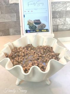 a bowl filled with food sitting on top of a table next to a cell phone