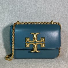 Eleanor Small Convertible Shoulder Bag/Cross Body Bag By Tory Burch. This Bag Is Made Of Brisk Blue Textured Genuine Smooth Leather. This Bag Is Convertible. Can Be Carried As A Shoulder Bag Or Cross Body Bag. Dimensions: 7.5" Wide Across Bottom X 5" Tall Center X 2.5" Deep. Strap Drop Doubled 11.5", Single 22". Interior: 3 Compartments. 1 Zipper Compartment Flap Closure Secured With Magnetic Button. Leather Interior. Gold Tone Metalware. Comes With Dust Bag !!! Luxury Blue Crossbody Shoulder Bag, Classic Blue Bags With Metal Hardware, Elegant Blue Shoulder Bag With Metal Hardware, Blue Rectangular Bag With Metal Hardware, Blue Rectangular Bags With Metal Hardware, Blue Crossbody Bag With Metal Hardware, Luxury Blue Bag With Metal Hardware, Designer Blue Satchel Shoulder Bag, Blue Shoulder Bag With Metal Hardware