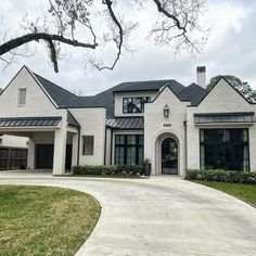 a large white house with black trim and lots of windows on the front side of it