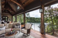 a living room filled with furniture on top of a wooden floor next to a lake