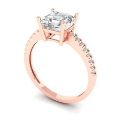 a rose gold engagement ring with an emerald center stone and side stones on the band