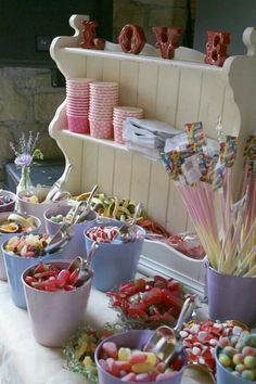 candy buffet with lots of colorful candies and lollipops in buckets