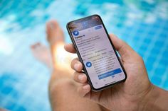 someone is holding their cell phone in front of the swimming pool royalty images and stock photos