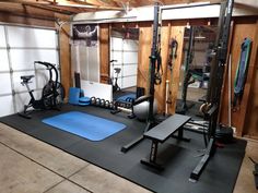 a home gym with several machines and exercise mats