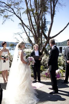 the bride and groom are getting married in front of an outdoor ceremony with their guests