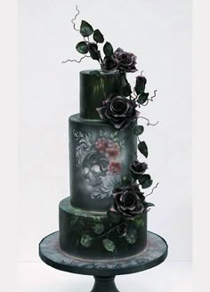 a three tiered cake decorated with flowers and skulls