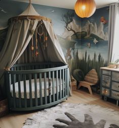 a baby's room with a crib, dresser and wall mural in the background