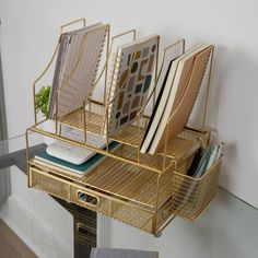 a gold desk organizer with books and magazines