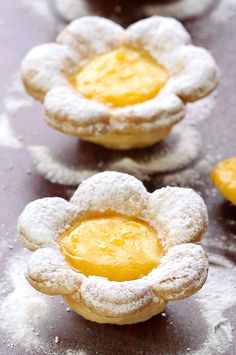 three small pastries with powdered sugar on them