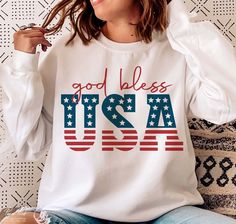 a woman sitting on a couch wearing a white shirt that says god bless usa