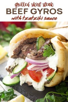 a beef gyro with tzatzh sauce and cucumber on the side