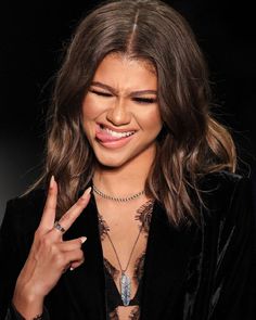 a close up of a person wearing a black jacket and holding a ring on her finger