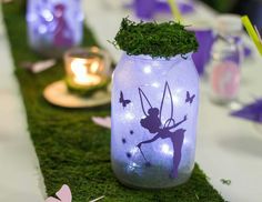 there are many jars with plants in them on the table, and one has a fairy tinker