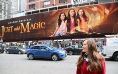 a woman standing in front of a movie billboard