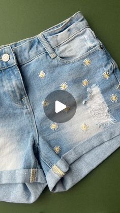 a pair of blue jean shorts with gold stars on them and a video play button