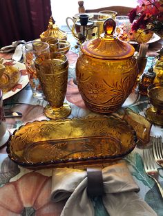 the table is set with gold colored dishes and silverware