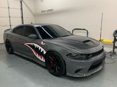 a gray car with shark teeth painted on it