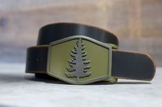 a green and black belt with a tree on it