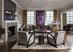 a living room filled with furniture and a fire place in front of a painting on the wall