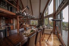 a living room filled with furniture and a wooden table in front of a large window