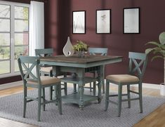 a dining room table with four chairs and a potted plant in the corner on top of it