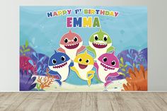 a birthday card with three cartoon sharks and corals in the background, on a wooden floor