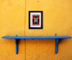 a blue shelf sitting next to a yellow wall