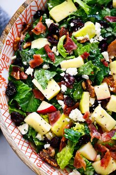 a salad with cheese, bacon and lettuce in a bowl