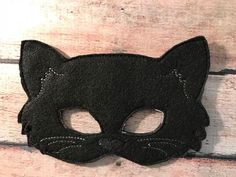 a black cat mask on a wooden surface