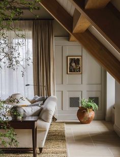 a living room filled with furniture and plants