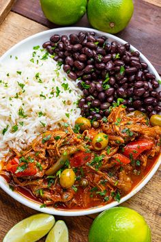 a white bowl filled with rice and beans next to limes