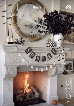 a fireplace decorated for halloween with black and white decorations