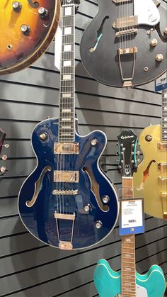 several guitars are on display in a music store, one is blue and the other is yellow