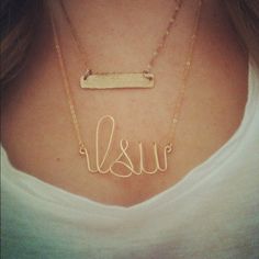 a woman wearing a gold necklace with the word lisur written in cursive font